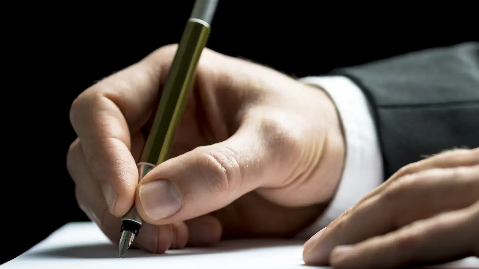 Main signant un document au stylo, illustration de l’accompagnement FOUNDY, courtier en crédit