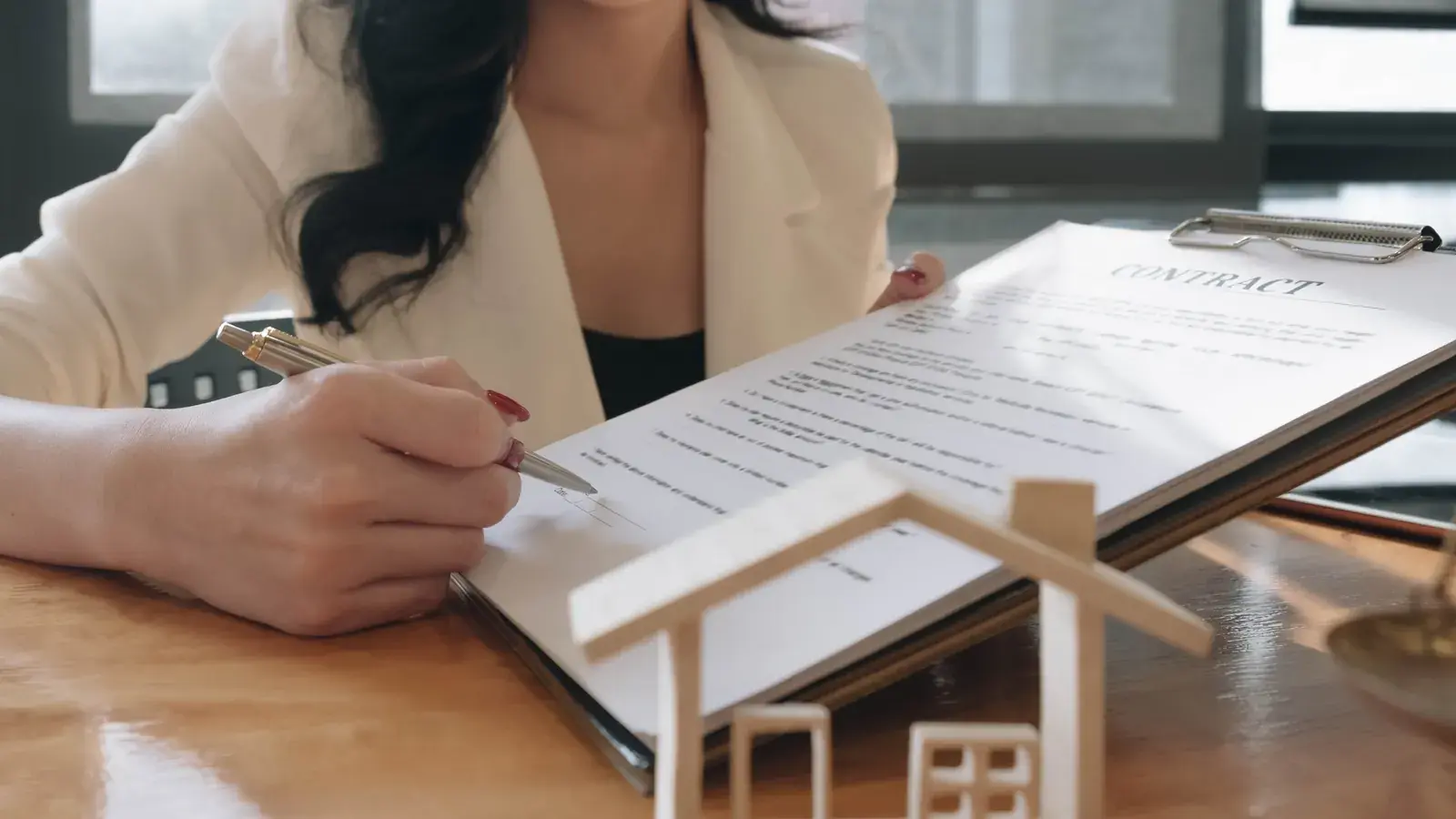 Femme signant une offre de prêt, illustration du crédit garanti par un bien immobilier avec FOUNDY